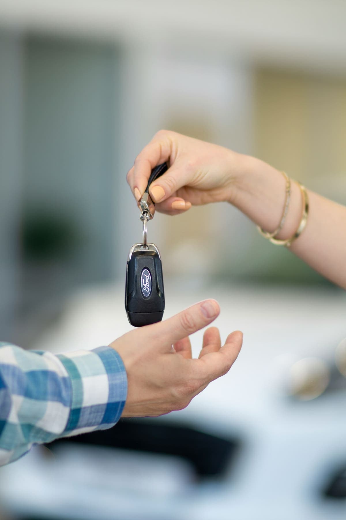 Une main tend les clés de la voiture à son propriétaire